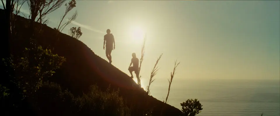 Two runners on a hillside above the sea at sunrise. Still from ROOTS, Alexis Berg / Little Hell